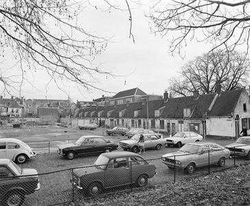 855665 Gezicht op de voorgevels van de krotwoningen in de Tuinstraat te Utrecht, vanaf het Geertebolwerk, met op de ...